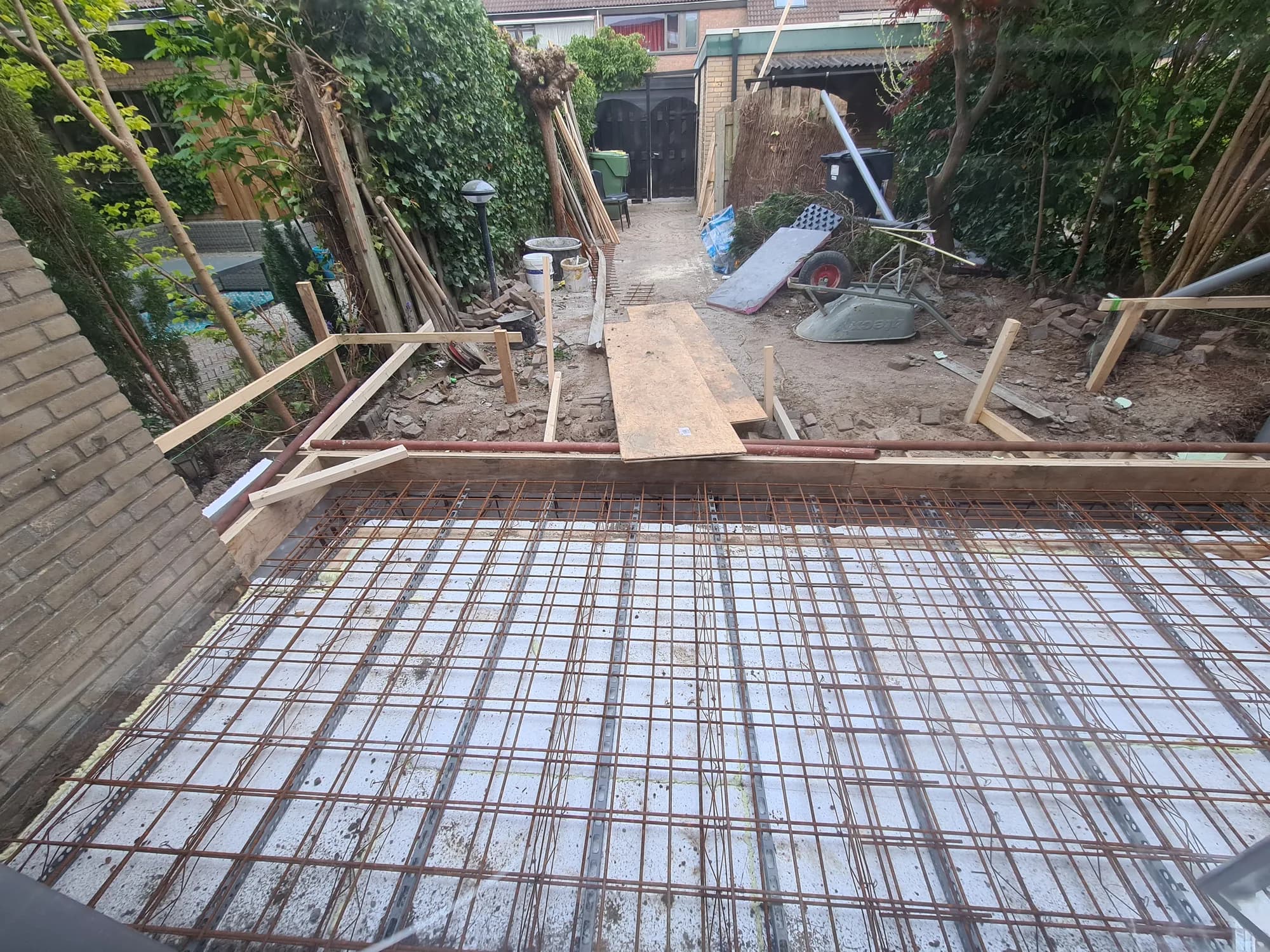 Gevlochten wapening voor een betonnen funderingsvloer van een aanbouw in een achtertuin